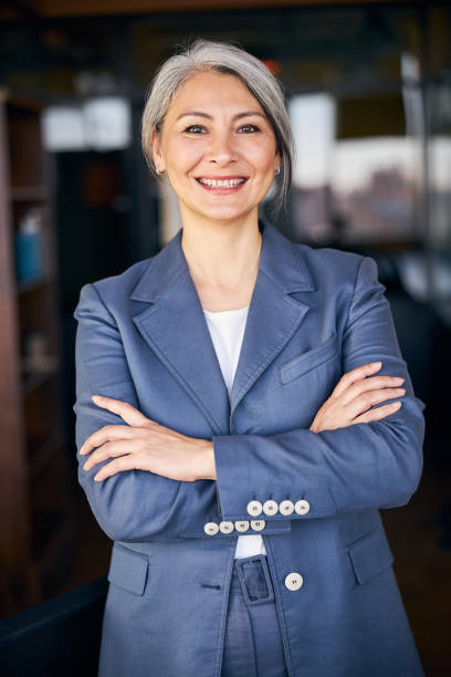 istock Joyful woman with crossed arms standing in office 1283342271