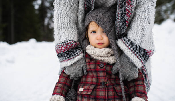 istock Unrecognizable mother with small daughter standing in winter nature. 1283342754