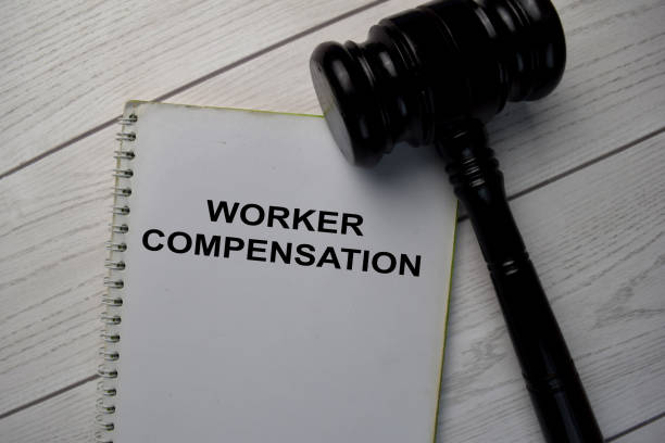 Book about Worker Compensation and gavel isolated on wooden table. Book about Worker Compensation and gavel isolated on wooden table. claim form photos stock pictures, royalty-free photos & images