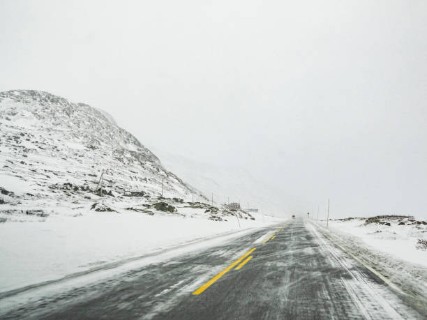 istock Driving through blizzard snowstorm with black ice on road, Norway. 1283344083