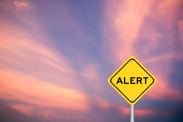 Yellow transportation sign with word alert on violet sky background