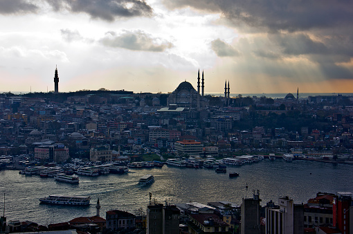 Istanbul, Turkey - December 14, 2013: There is a panaromic istanbul wiev with Karakoy,suleymaniye mosque. It's a medieval stone tower in the Galata/Karakoy quarter of Istanbul, just to the north of the Golden Horn and one of the city's most striking landmarks. Boats are anchored to Eminonu pier where is near the New(yeni) Mosque waiting for its passengers to get on board.