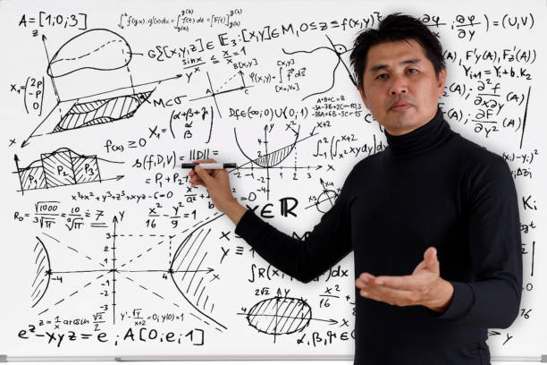 istock Mature professor teaching mathematics to students in classroom. Teacher man solving math problem while writing on white board with video conference. Covid-19 learn from home. 1283344416