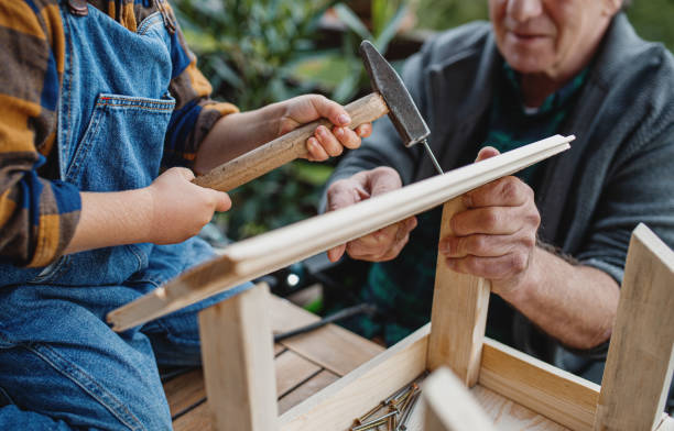 istock Unrecognizable small boy with senior grandfather constructing birdhouse, diy project. 1283347350