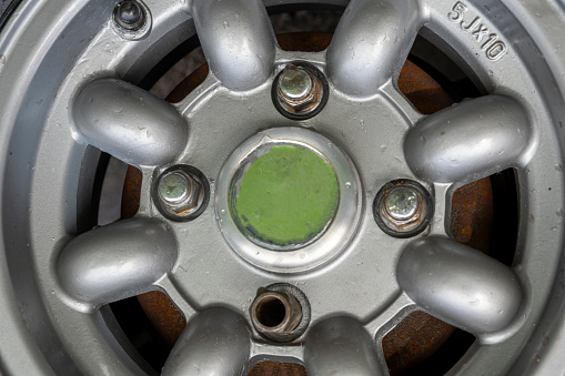 These are the Alloy wheel rims of a 1974 vintage car undergoing refurbishment.  This is a close-up of the rim after refurbishment with tyres refitted and back on the car and newly washed.