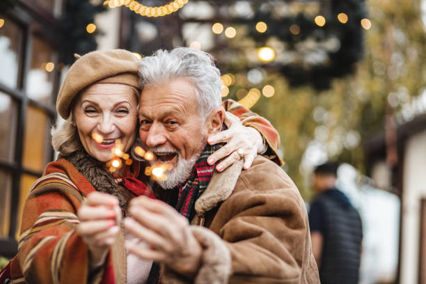 istock Senior couple is holding Christmas sparkles and smiling 1283348614