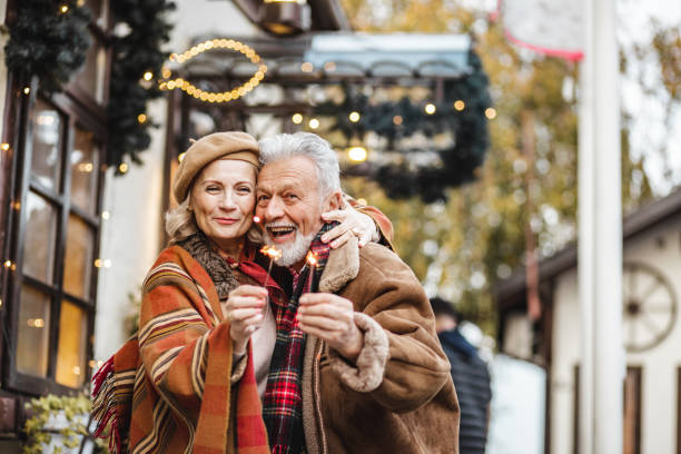 istock Senior couple is holding Christmas sparkles and smiling 1283348700