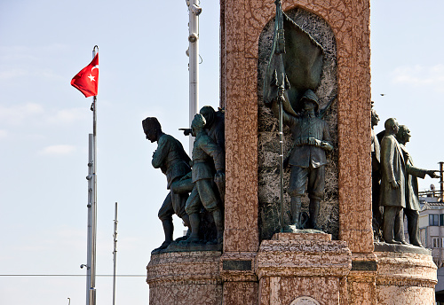 Istanbul, Turkey, February 17, 2019: Monument of Republic is sculpted by the Italian sculptor Pietro Canonica in 1928, Rome, Italy. Monument named 'Cumhuriyet Anıtı' to founder of Turkish Republic 'Atatürk' at Taksim square in Istanbul. People hang around it.
