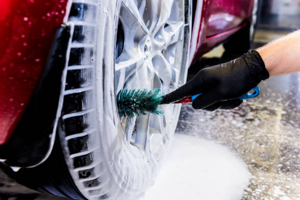 istock Cleaning the car wheel with a brush and water 1283349585