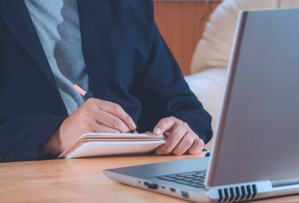 istock Businessman writing and reading notebook on work table for financial inspector and making report financial planning report from laptop. vintage tone. 1283349754