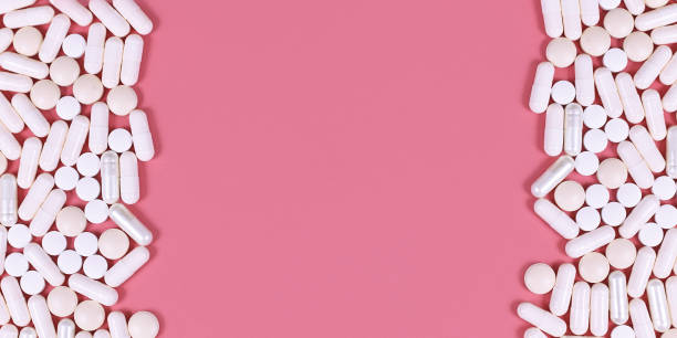 istock Banner with white capsule pills on  pink background with empty copy space 1283349784