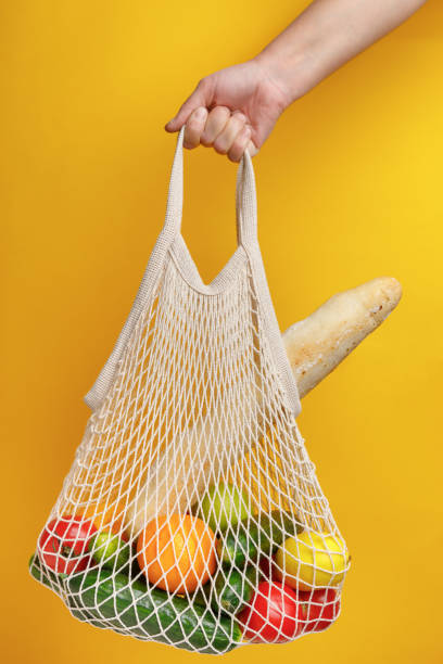 istock woman holding mesh shopping bag. 1283349922