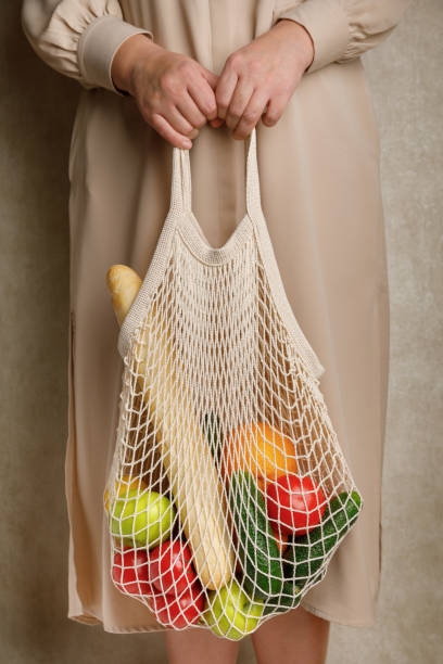 istock woman holding mesh shopping bag. 1283350053