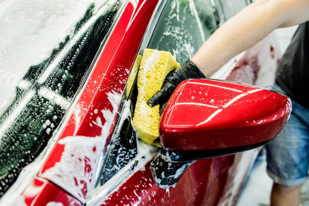 istock Worker washing red car with sponge on a car wash 1283350510