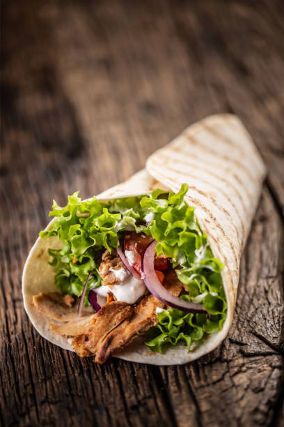 Wrapped tortilla with meat, onion and salad Wrapped tortilla with meat, onion and salad. mexican culture food mexican cuisine fajita stock pictures, royalty-free photos & images