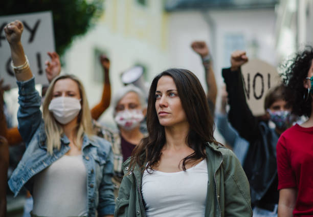 istock Group of people activists protesting on streets, demonstration and coronavirus concept. 1283353513