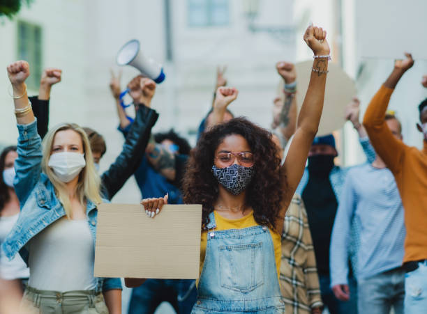 istock Group of people activists protesting on streets, demonstration and coronavirus concept. 1283353546