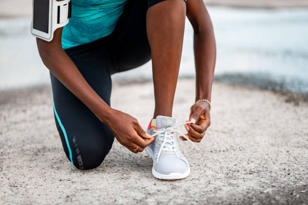 istock Athlete crouching while tying the sneakers 1283354386