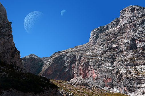 fantastic extraterrestrial landscape with a rocky gorge and two moons in the sky