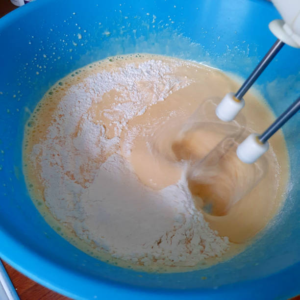 istock Preparing the cake. Mixing flour with dough with a mixer. 1283354614