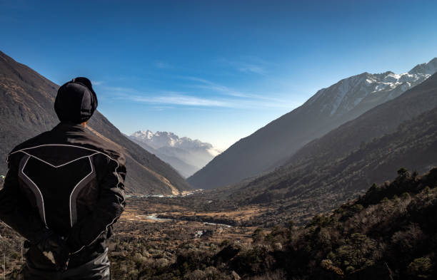 istock men biker watching Himalayan valley leading to snow peak with blue sky 1283357468