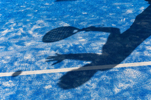 ombra di un uomo che gioca a paddle sul campo da paddle - padel foto e immagini stock