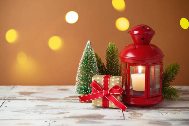 istock Christmas holiday background with lantern, gift box, and pine tree decor on wooden table. Winter greeting card. 1283365511