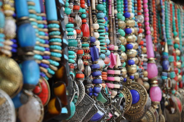 Colorful jewellery, necklaces, accessories and ornaments for sale at a street side shop in a bazaar Colorful ornaments, necklaces, jewellery, bangles and accessories hanging from the frontage of a street side shop in a bazaar. sabby stock pictures, royalty-free photos & images