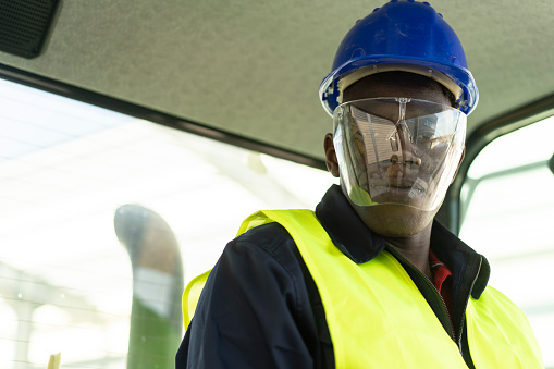 Portrait of an young construction worker wearing protective face shield during his work
