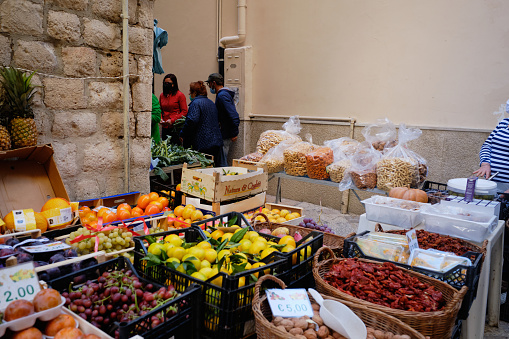 Bari, Italy - October 20, 2020: Fresh Food Store in a Street of The Old city of Bari, some people in the street bying fresh vegetables and freuits