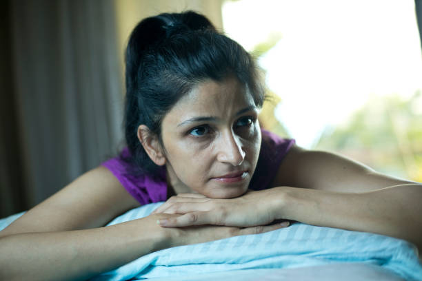 istock Depressed woman lying in bed at home 1283369292