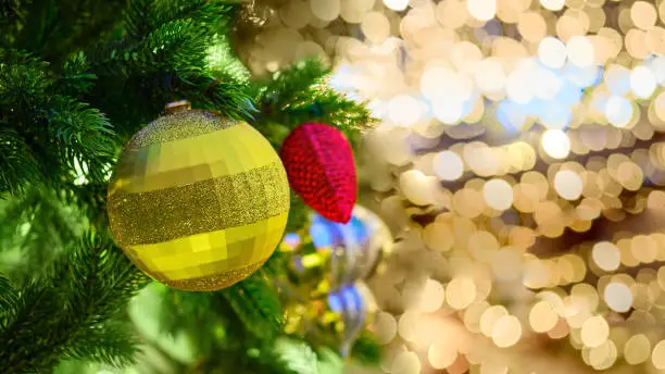 Photo of Gold ball and red pine cone on the christmas tree and yellow bokeh, new year copy space