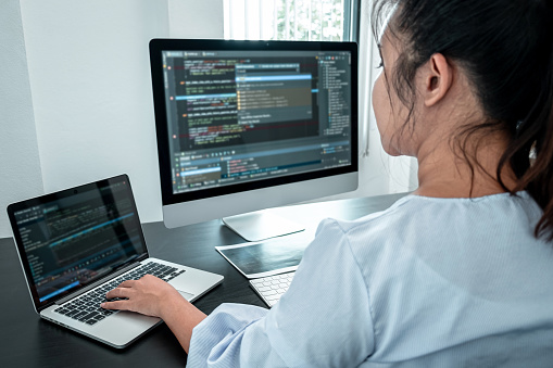 Female Developer programmer working on coding program software computer, Writing website and development database technology in office.