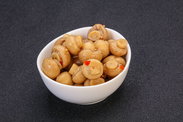 Pickled champignons with spices in the bowl