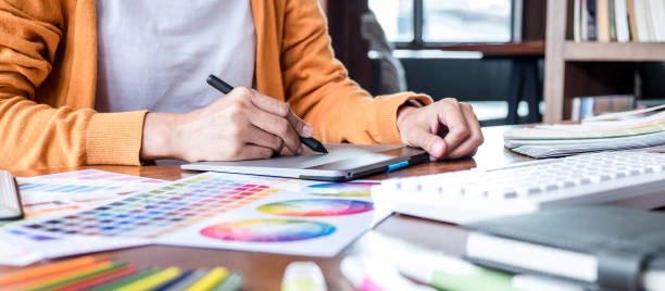 istock Image of female creative graphic designer working on color selection and drawing on graphics tablet at workplace with work tools and accessories 1283374021