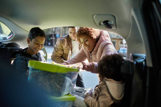 istock Young Family Unloading Containers from Car on Moving Day 1283374556