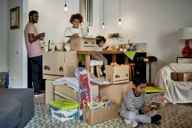 istock Parents with Young Children Unpacking Boxes on Moving Day 1283374562