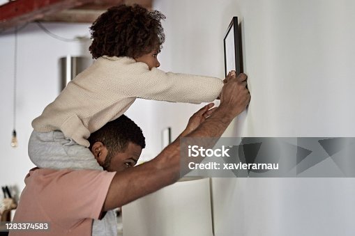 istock Father with Young Daughter on His Shoulders Hanging Picture 1283374583
