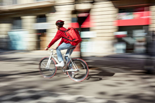 istock Bicycle Messenger on the Move Delivering Pizza to Customer 1283374615