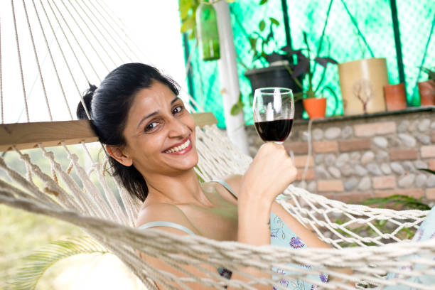 istock Woman drinking wine relaxing in hammock 1283375986