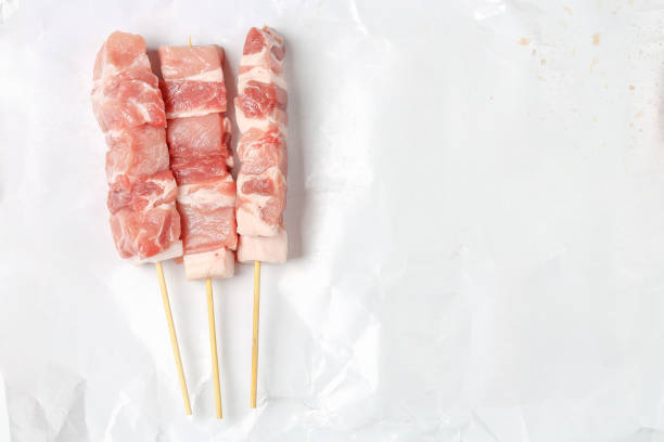 close up of three raw souvlaki, top view, meat background