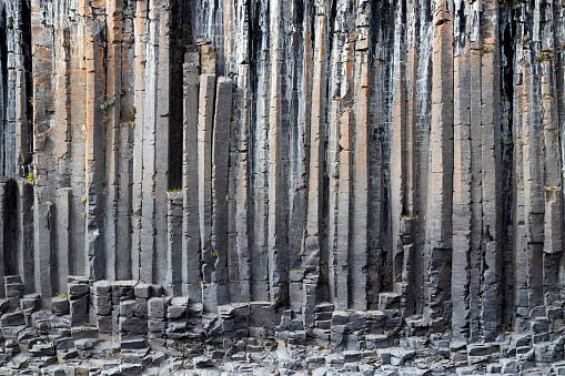 The wall of basalt columns in Studlagil canyon in Jokuldalur Valley in Iceland. Texture of a volcanic basalt rock. Background concept about nature and geology.