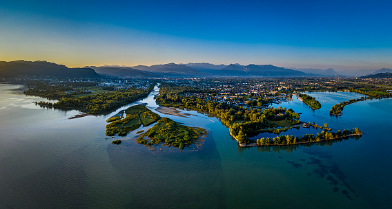 Aerial view of the Bregenzerach estuary in the morning at the shore of Lake of Constance in Austria. On the left side the city Bregenz, on the right side the village Hard