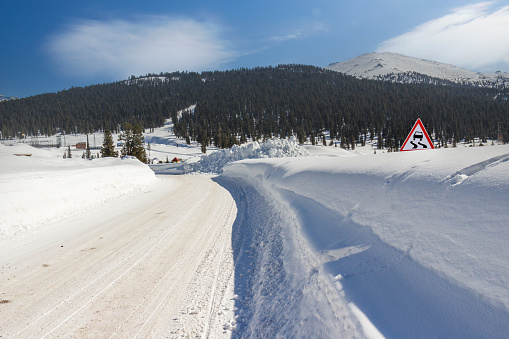winter road covered with snow on sunny day. Ergaki mountain range, Western Sayan Mountains at southern Siberia, Russia