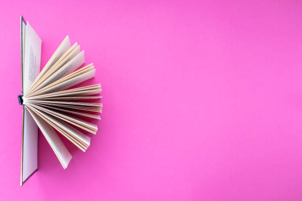 Open book on pink background. stock photo