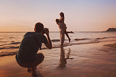 wedding portrait photographer taking photos of honeymoon couple on the beach