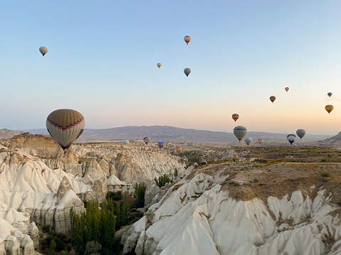 Hot air balloons at morning ober the beautiful landscape in Cappadocia, Turkey