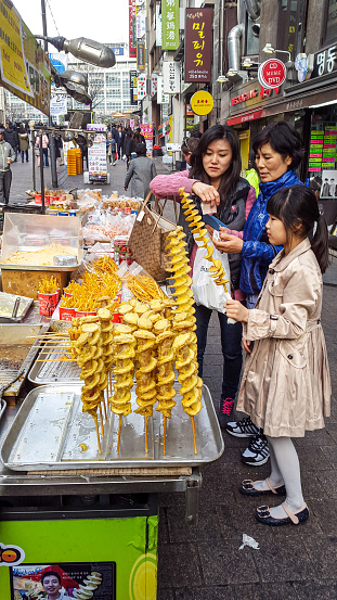 In March 2015, a family is buying street food in the streets of Seoul.