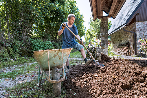 Man Removing the Soil from the House Entrance to Prepare a New Yard Area