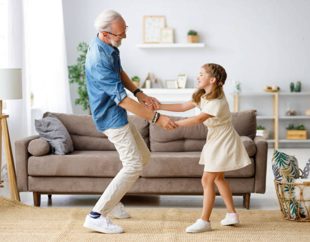 istock Grandfather dancing with granddaughter at home 1283386349